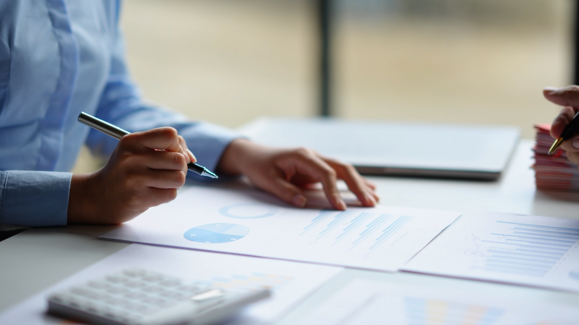 Person reviewing charts and documents representing strategic sourcing and procurement planning